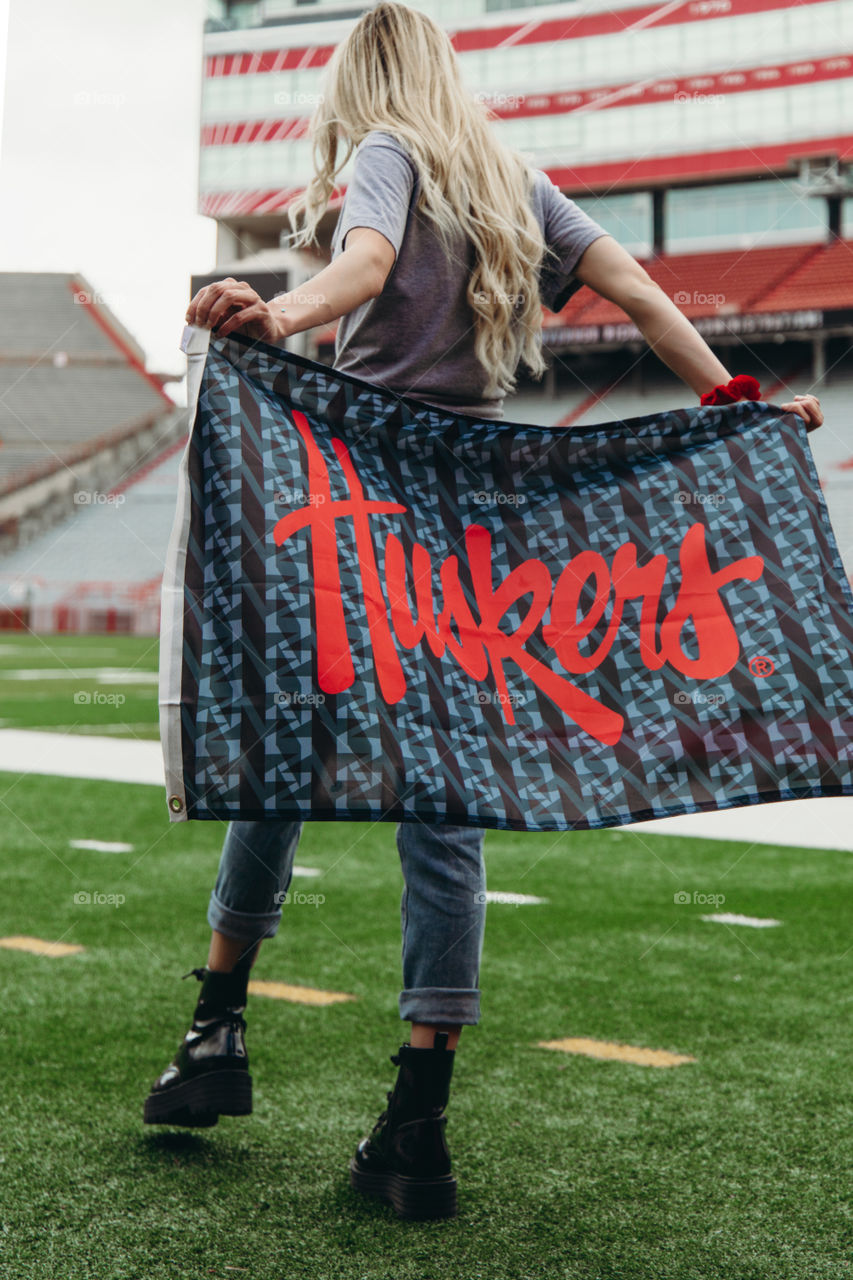 Holding the Husker flag at Memorial Stadium on the field supporting Ronald McDonald House Foundation 