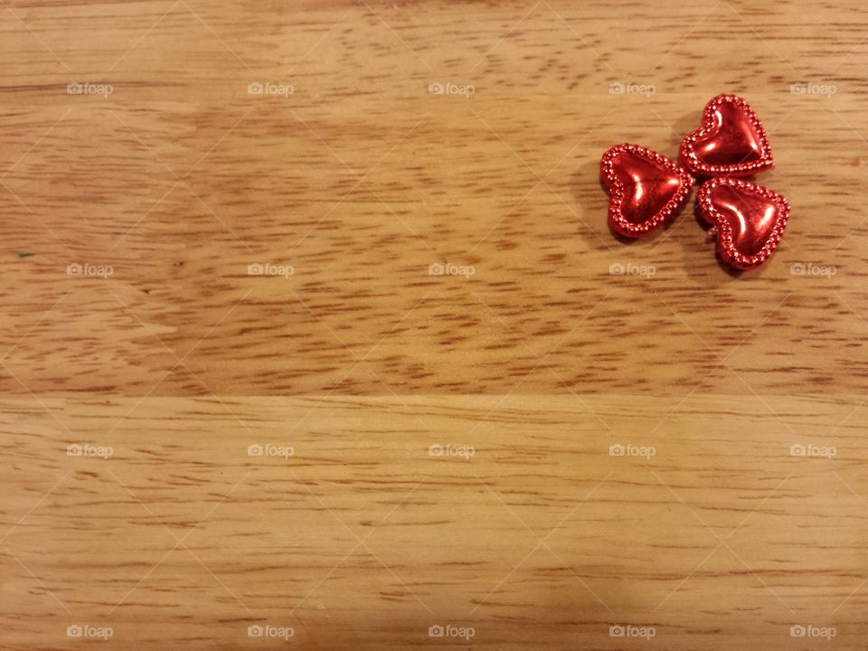 shiny red hearts on wooden background
