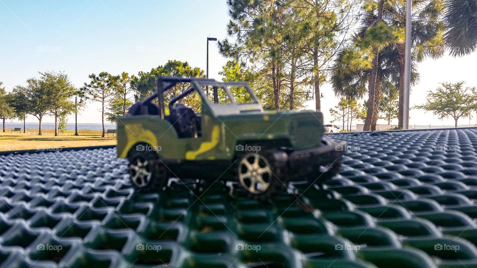 military jeep toy over picnic table , trees in the background