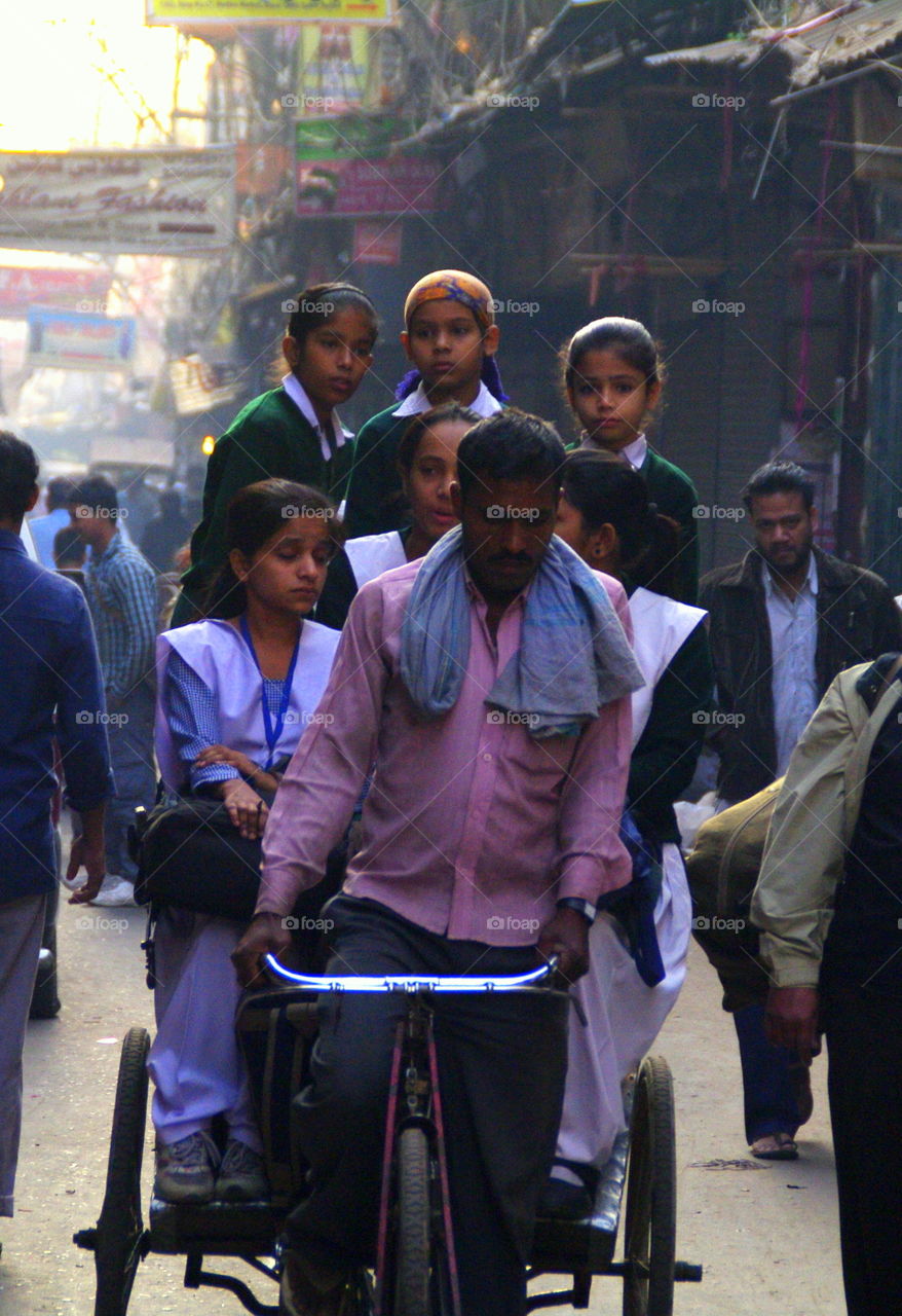 Man riding rickshaw with schoolgirl