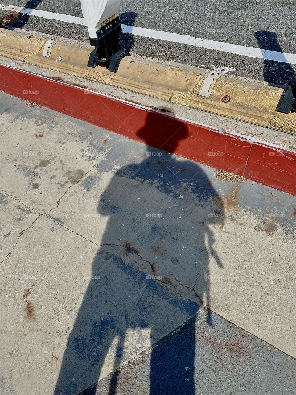 Theatrical shadows are cast onto the pavement of the pedestrian lane of the „Pulaski Bridge“ at „Newtown Creek“ that connects „Greenpoint“, Bklyn to LIC, Queens at a certain time in the afternoon when the sun begins to set. 2024. Hypnotic Productions