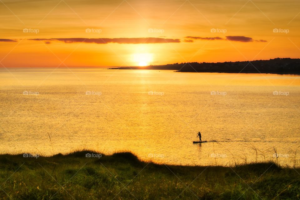 Peddle boarding in Atlantic ocean at golden hour