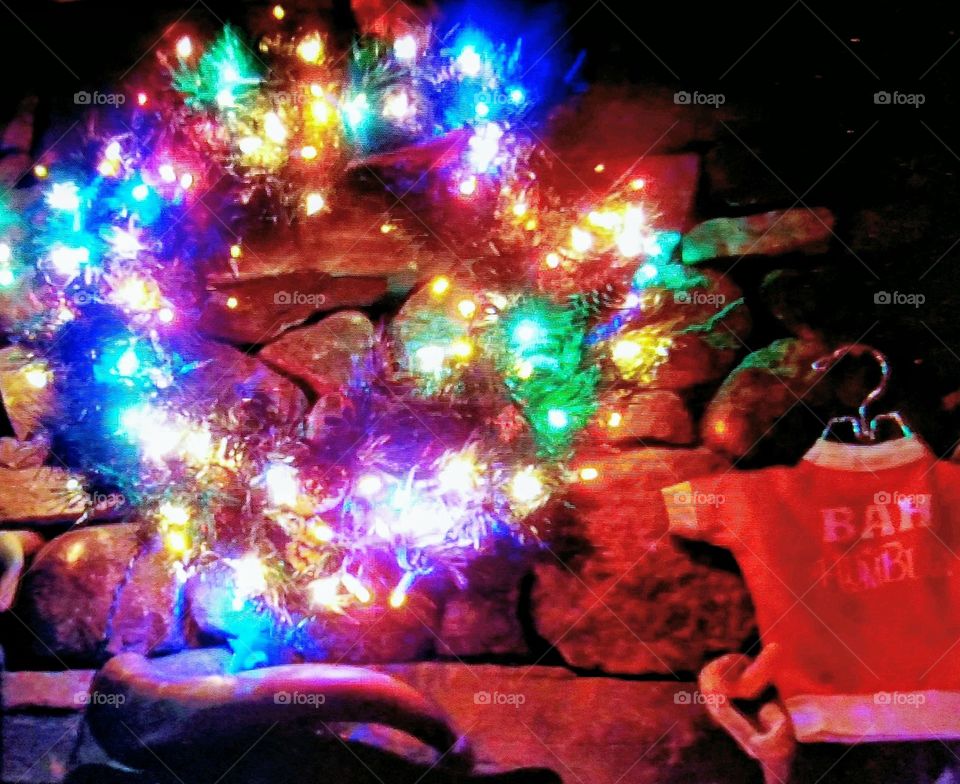 Bah Humbug tee shirt & Christmas wreath hanging above mantle, multicolored lights cast a nice glow.