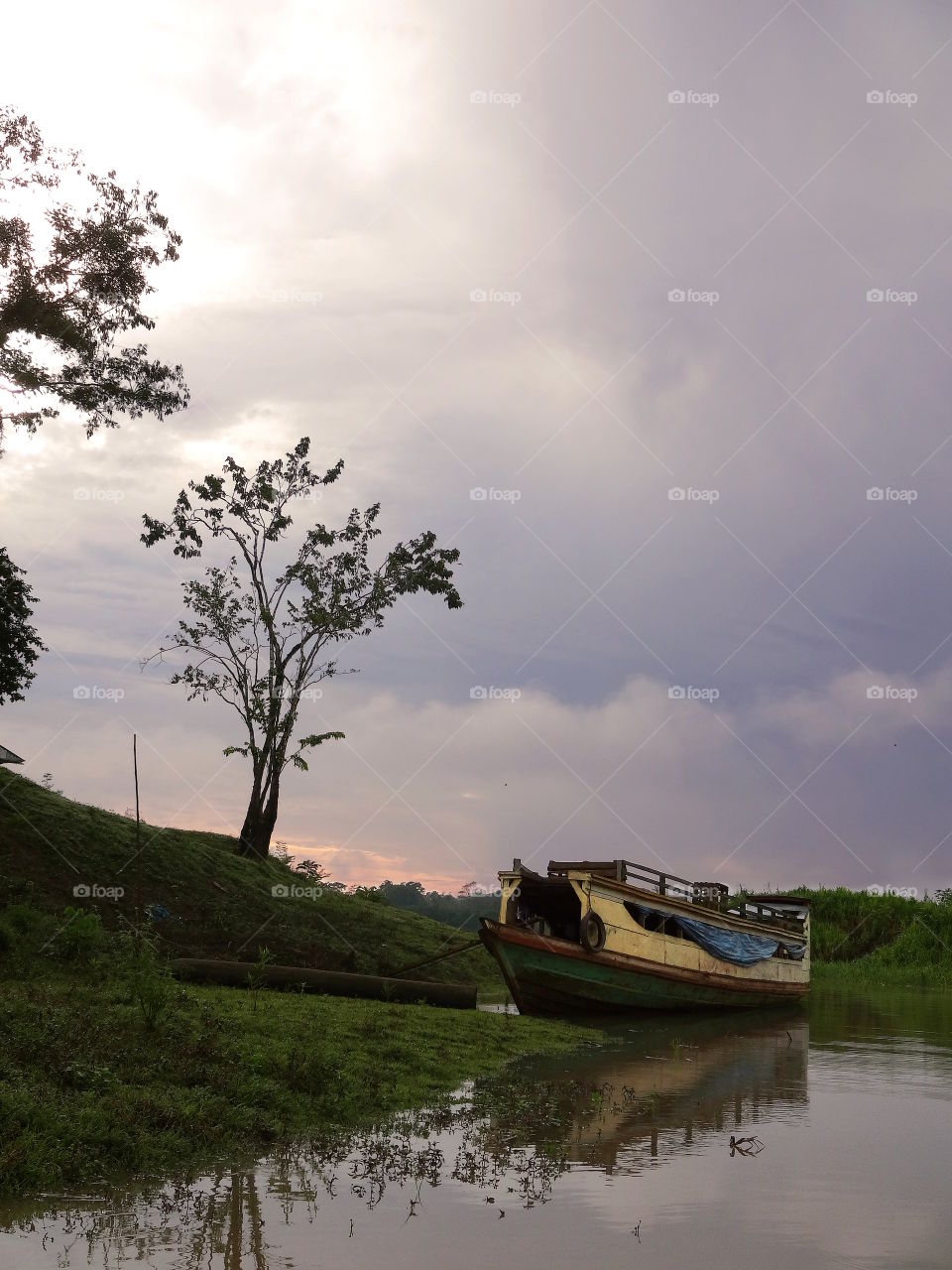 Amazon river house boat under purple evening sky