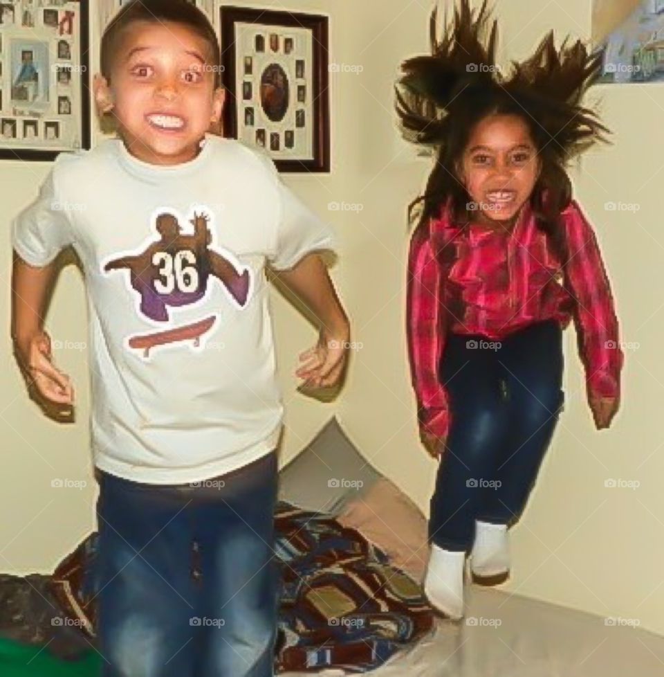 Joy . Children jumping on a bed