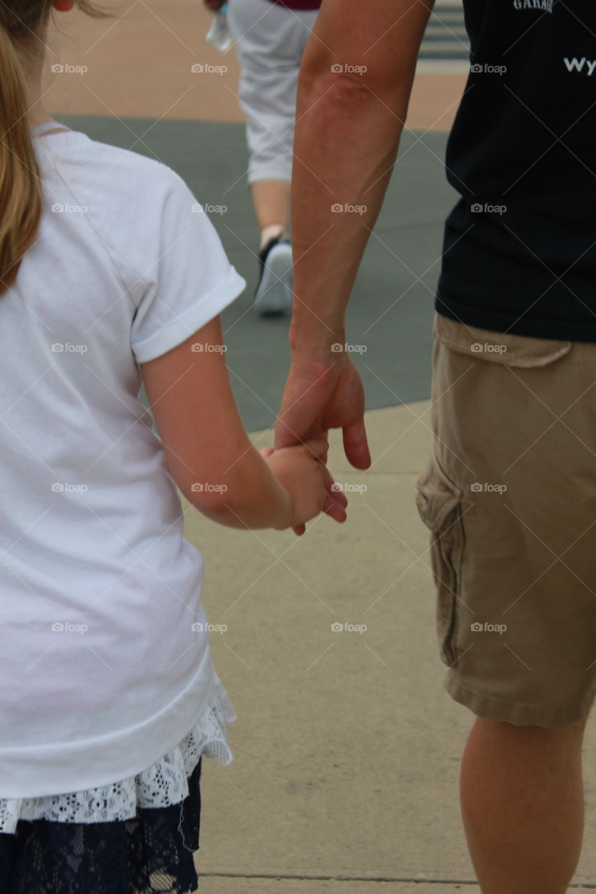 Daddy daughter bonding. Daddy and daughter holding hands