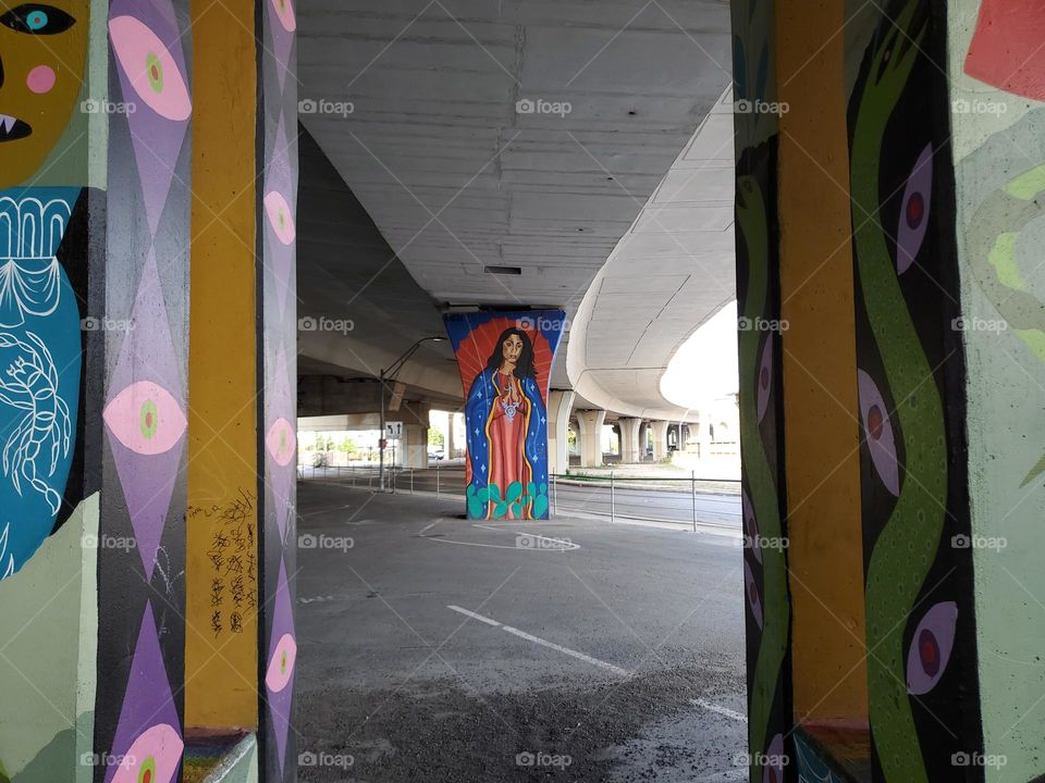 Colorful urban street art under a highway.