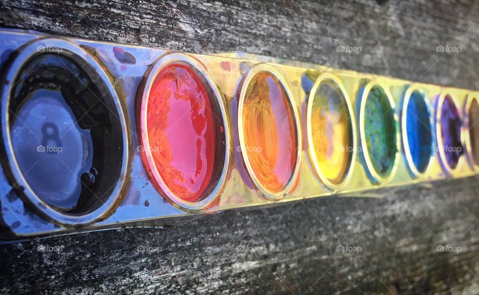 Watercolors in messy palette on wall