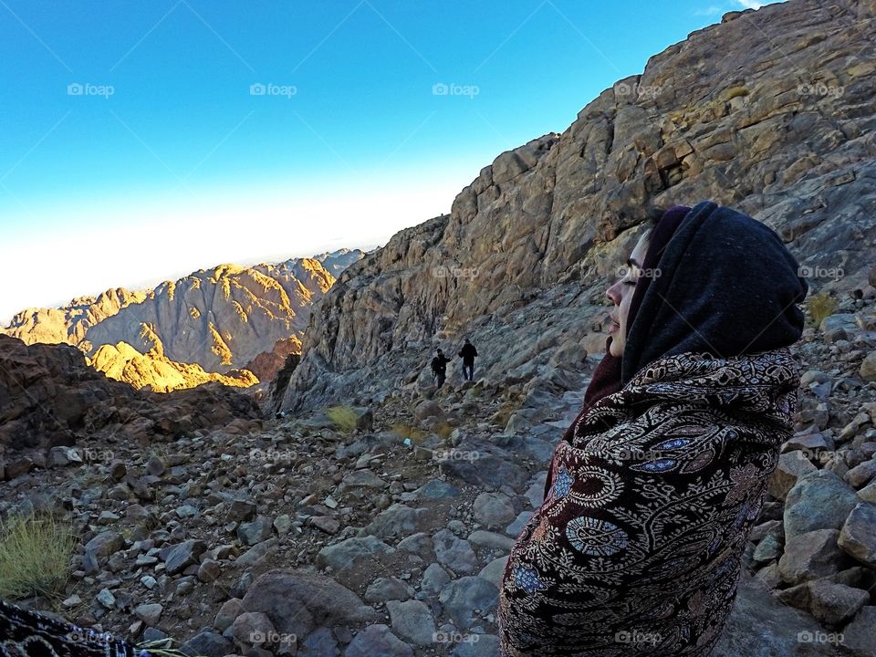 Girl meditating on the way down from mount sinai by the dawn, sinai, Egypt. 