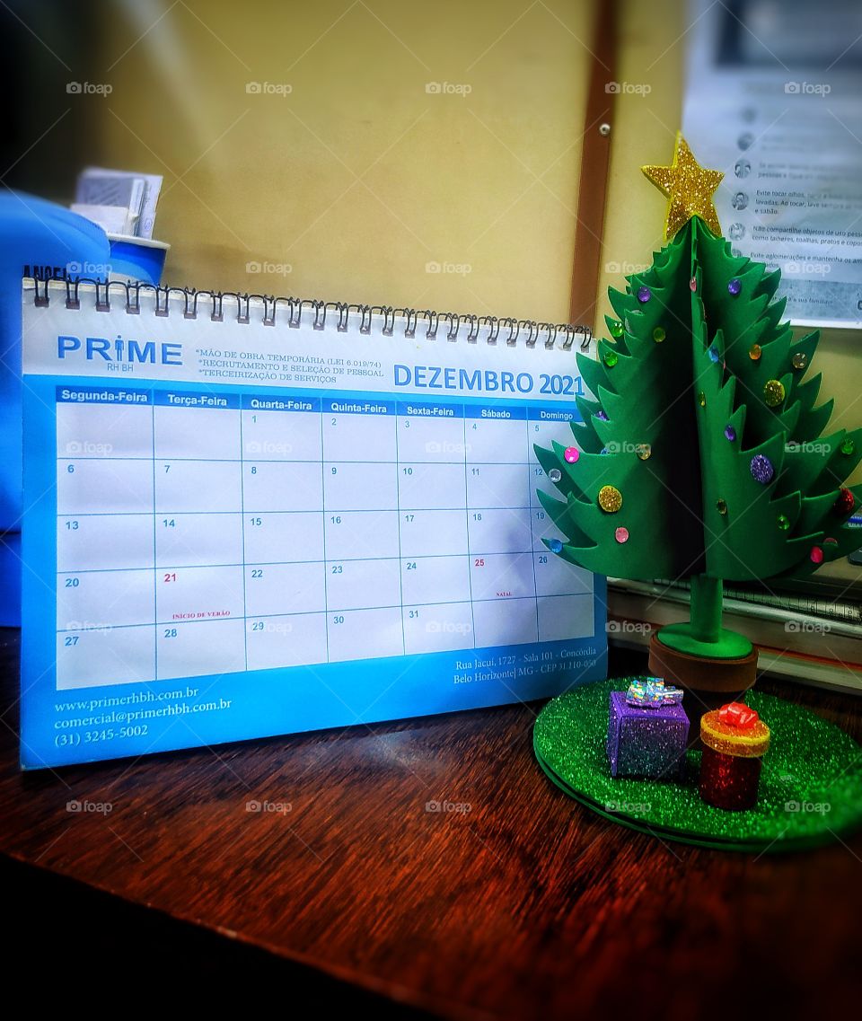 Calendário brasileiro destacando o mês de comemoração natalina ,e uma pequena árvore de natal feita a mão