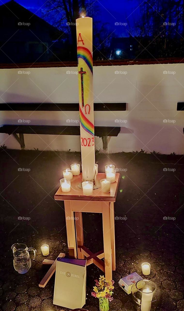 In “Garmisch Partenkirchen” on “Easter Sunday” at 4:00 AM when it’s still dark outside a fire is lit and people gather round in the churchyard. A large specially crafted Easter candle is also lit & the church bells ring. 2023. Hypnotic Productions