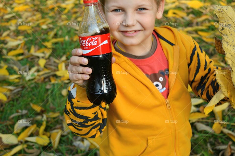 coca cola in the hand child outdoor autumn time