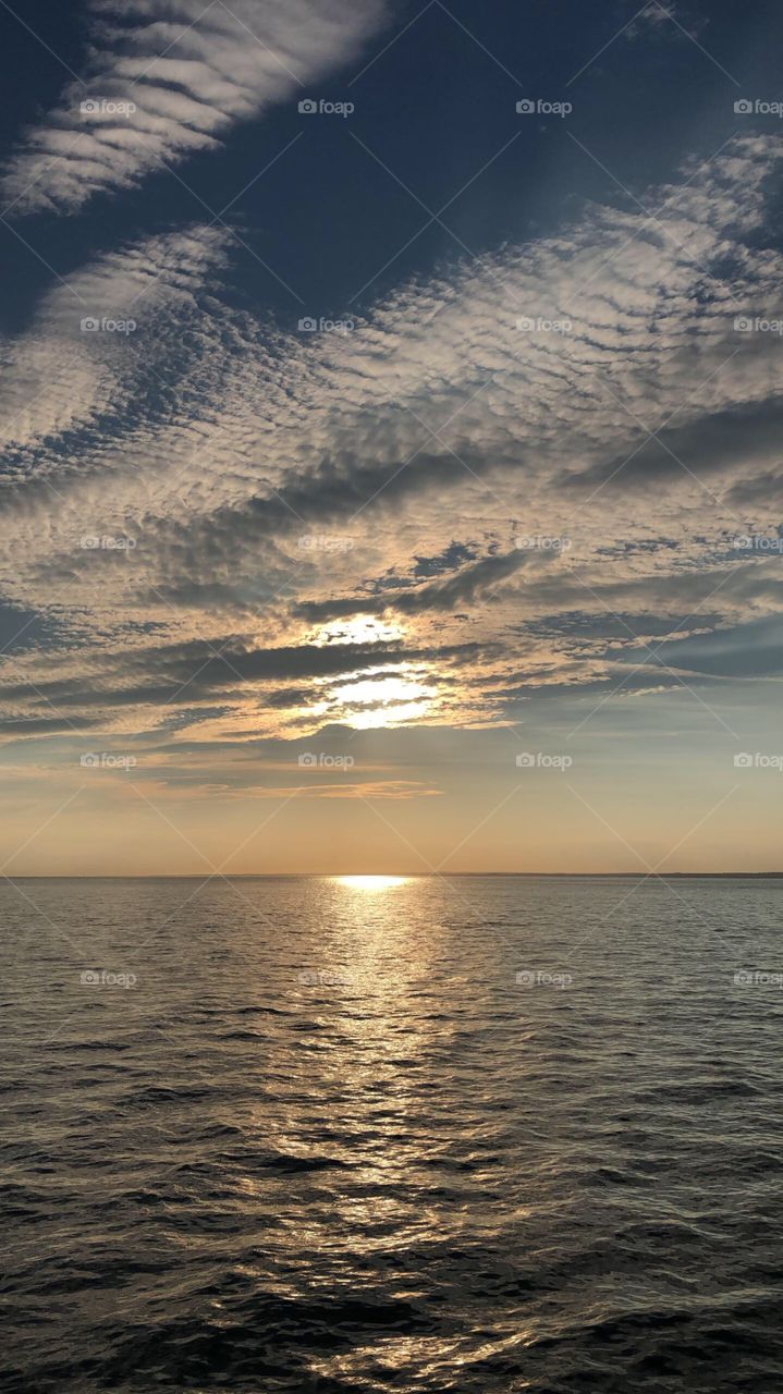 The sun sets against the beautiful ocean off the coast of the hamptons
