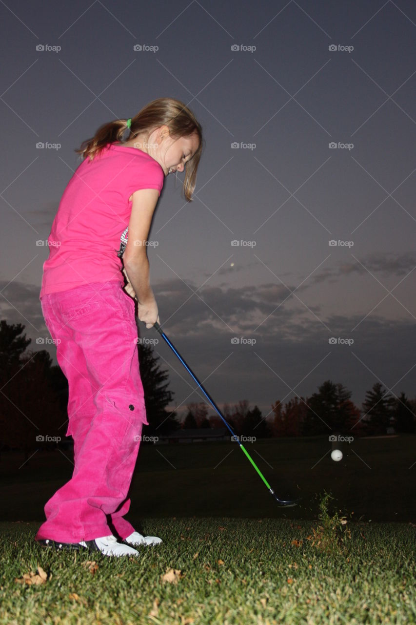 Par 4 approach shot. My daughter making her second shot out of the fairway on the eighteenth green ending a fine evening of golf