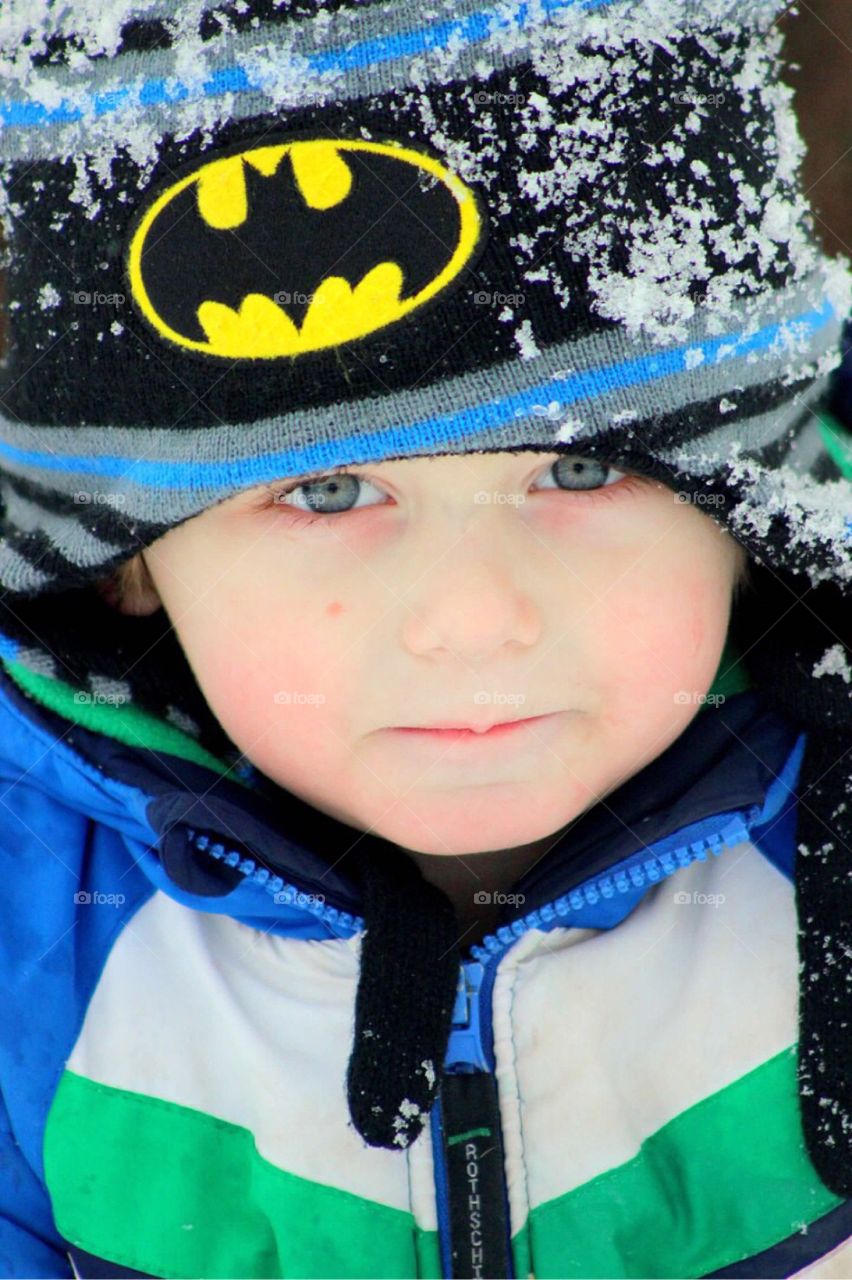 Close-up of boy with snow on cap