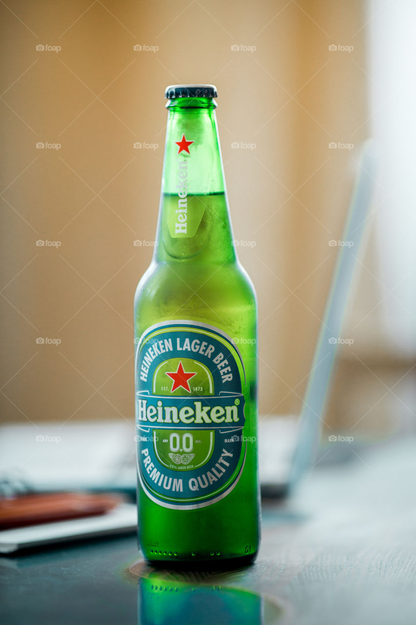 bottle of nonalcoholic Heineken beer on desk