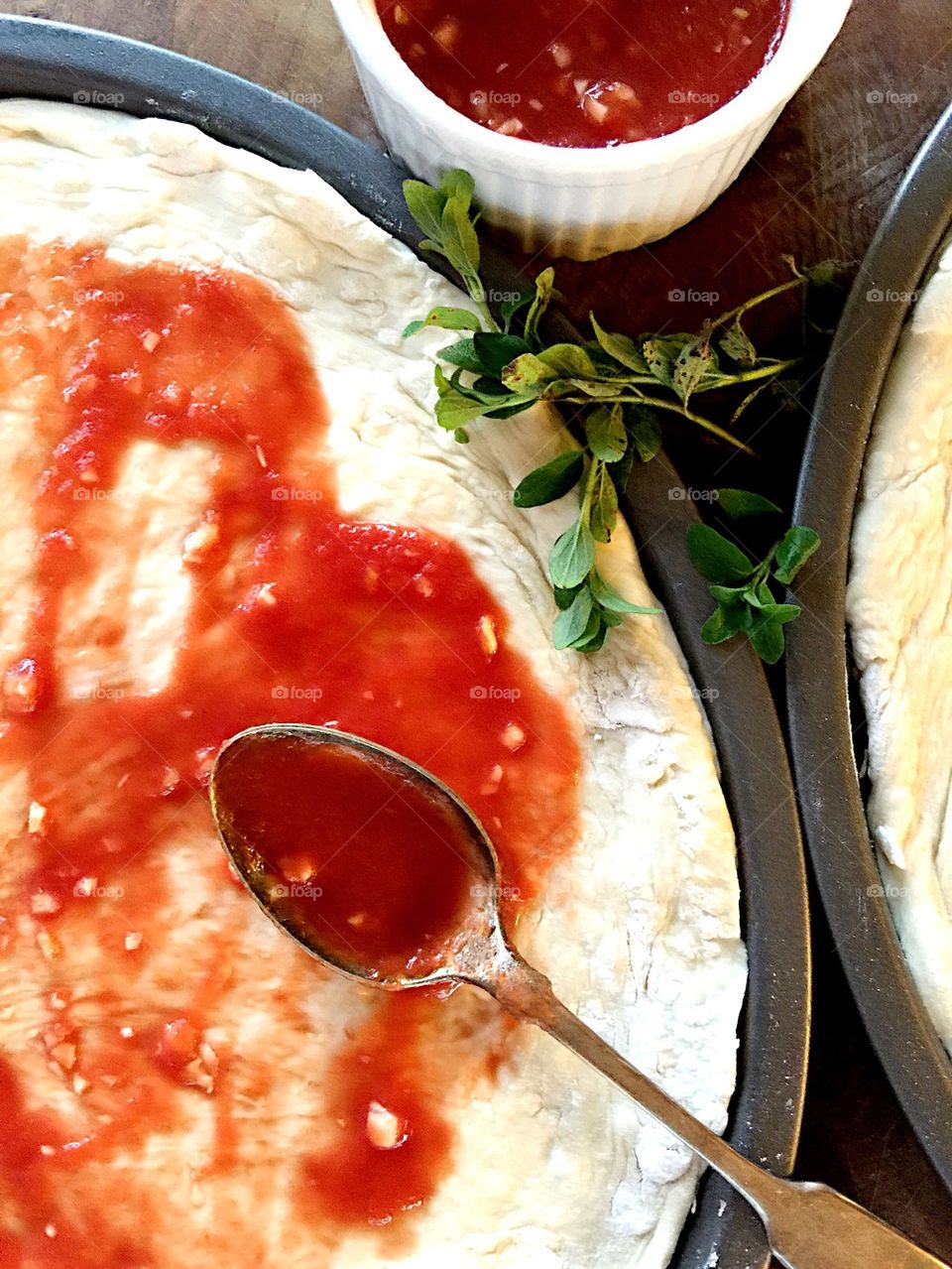 Putting sauce on pizza dough