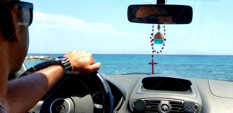 Car#driver#hand#indoor#view#sea#sky#sun#travel