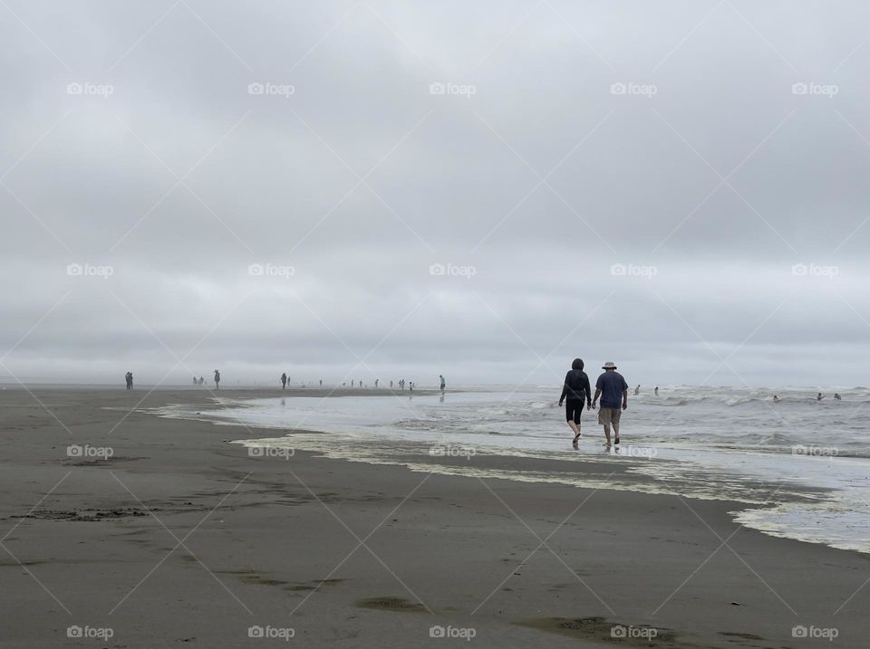 Couple walks on the ocean shore 