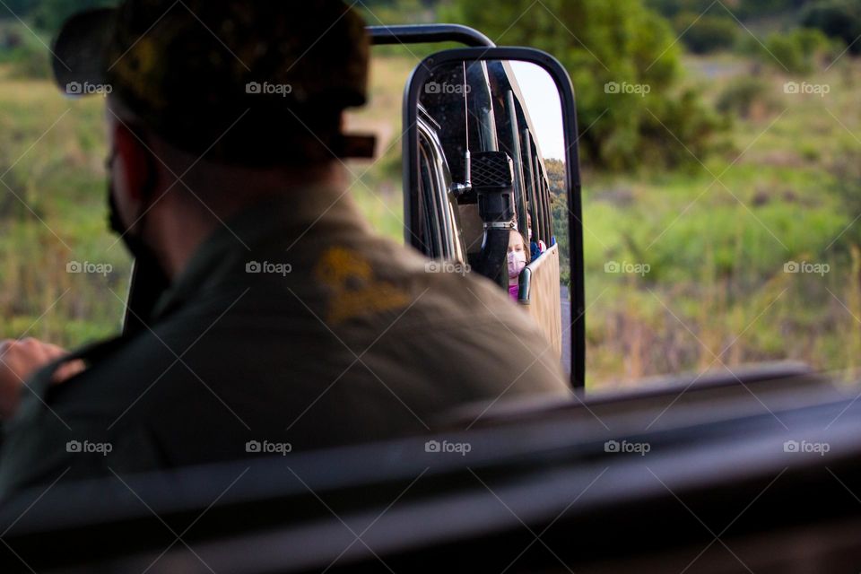 The game drive. Girl with face mask on safari