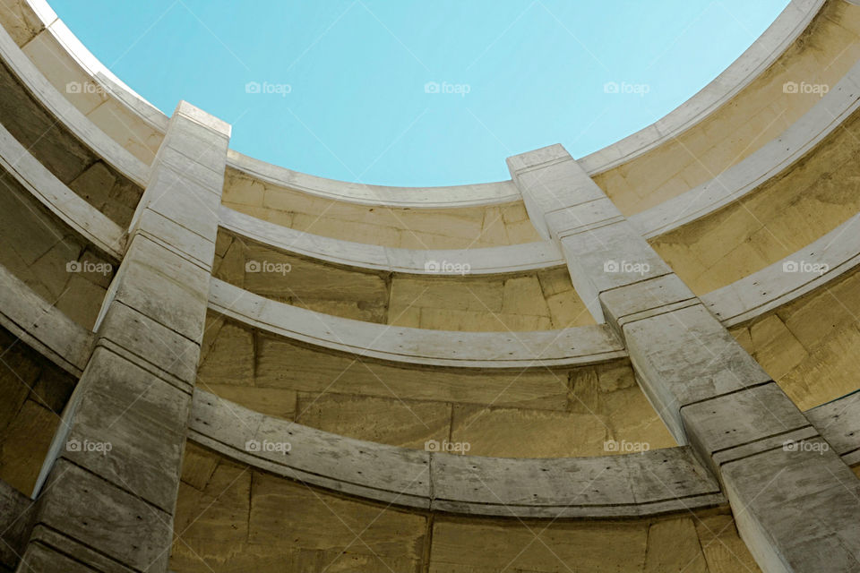 Old concrete parking garage nice round lines and cracks with soft blue sky.