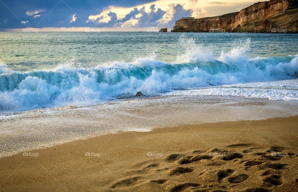 Blue waves crash on a sandy beach