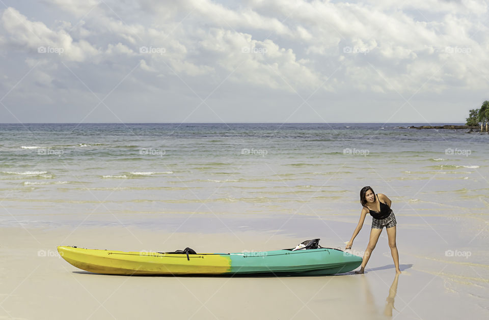 Asian women and kayaks on the beach Background sea and sky at Koh Kood, Trat in Thailand.