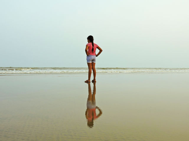 Girl standing on a sea beach