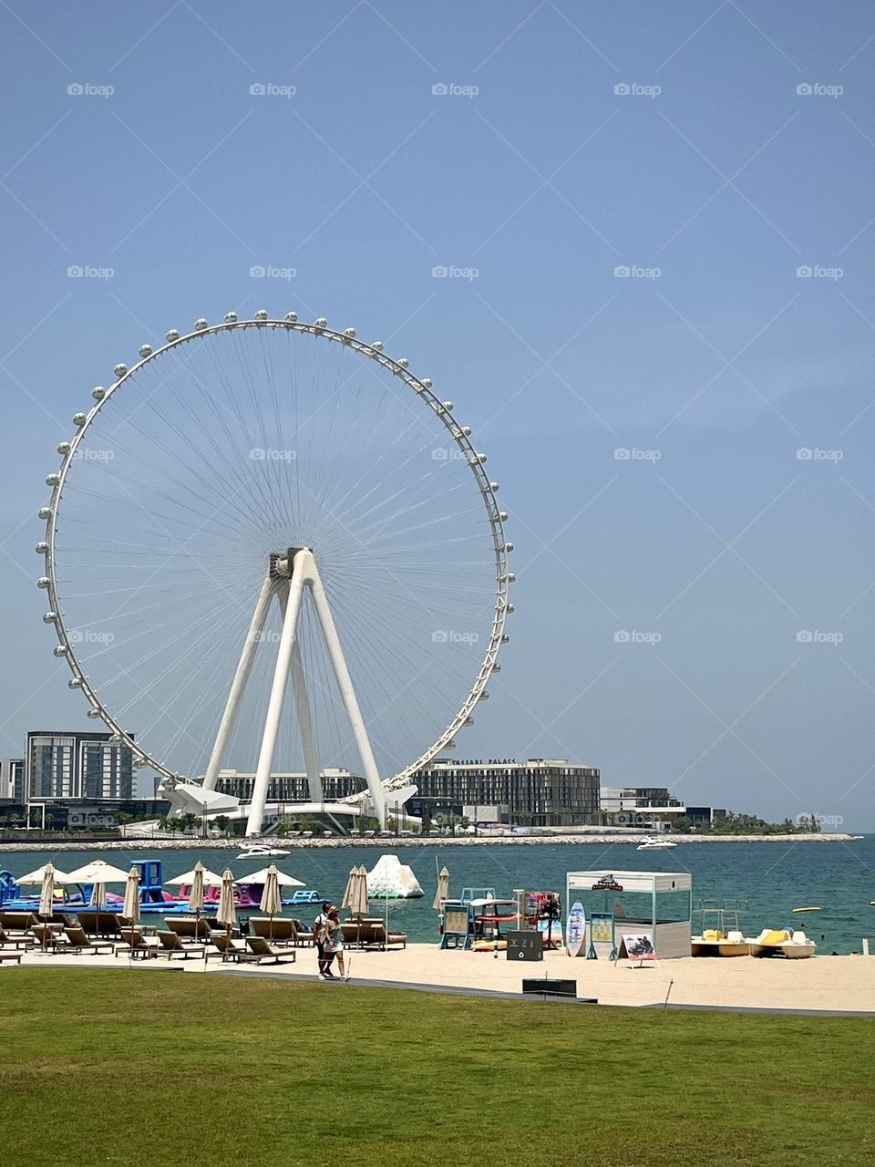 View of a dubai beach with a Ferris wheel in the background