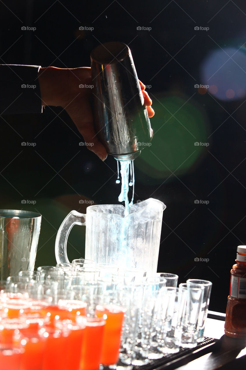 Barman serves a round of just mixed cocktail spirits