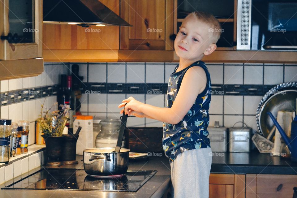 Happy boy helps with cooking