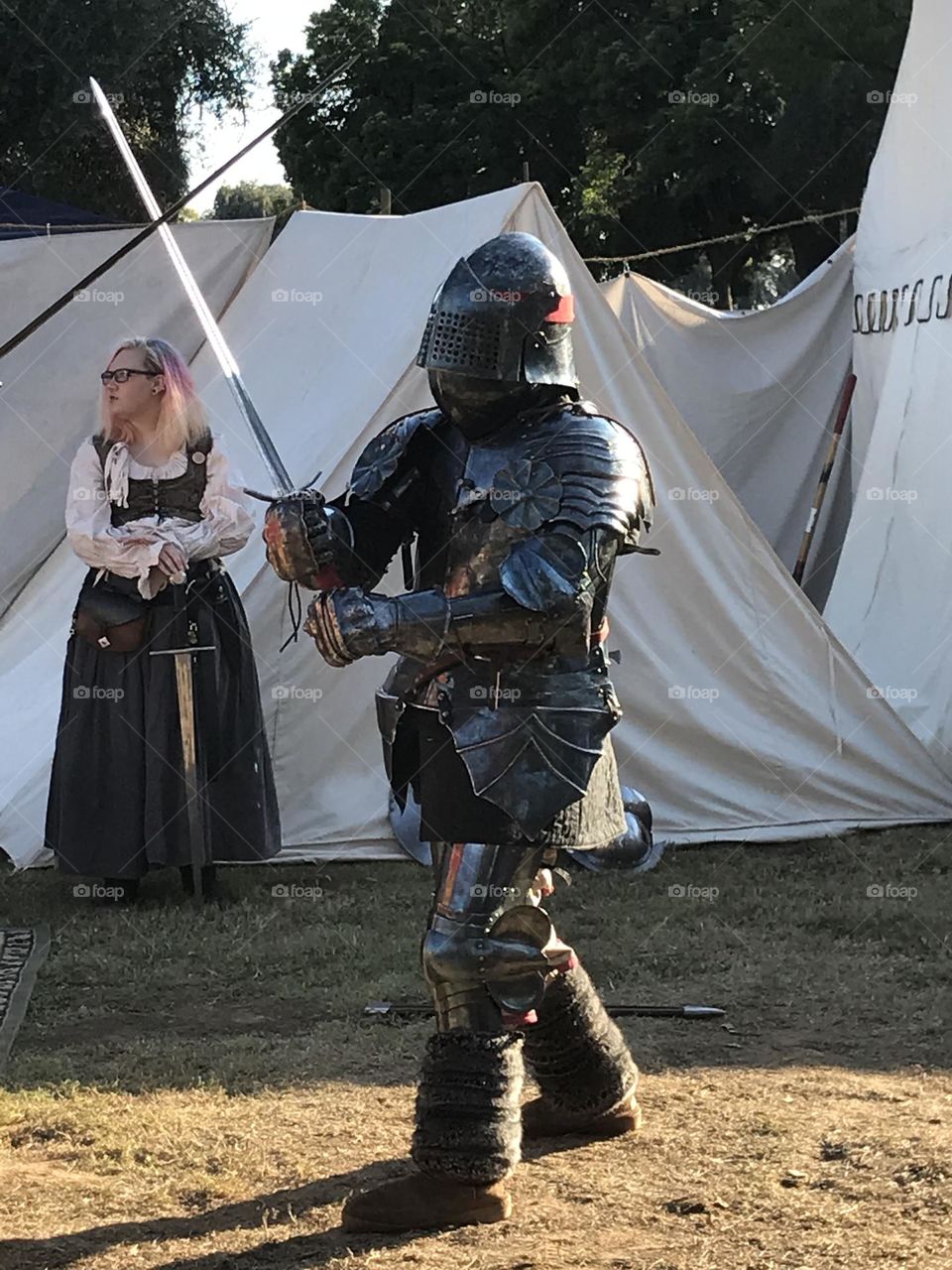 Crossing blades with an adversary. The medieval knight is participating in a sword arts demonstration at the Renaissance Faire.