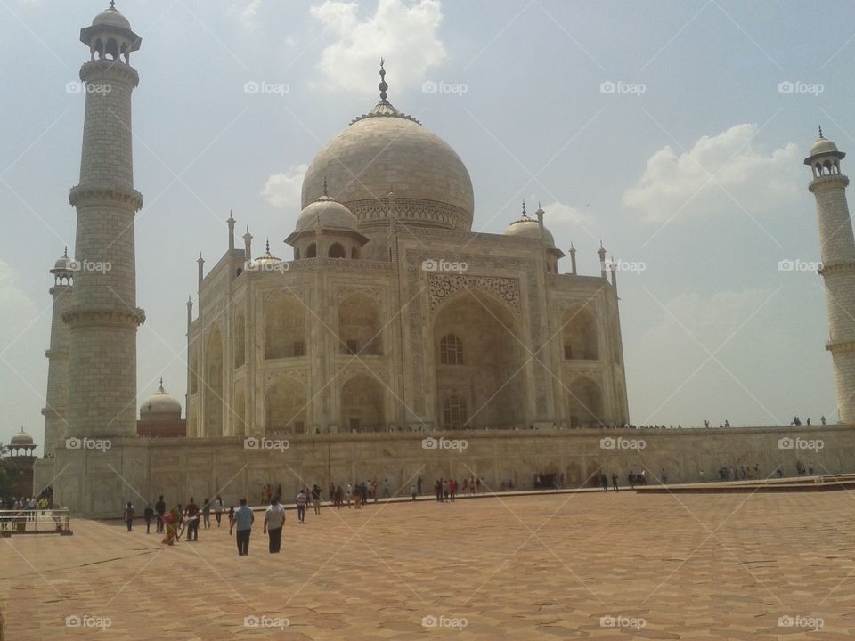 The Taj Mahal (/ˌtɑːdʒ məˈhɑːl, ˌtɑːʒ-/;[3] meaning Crown of the Palace[4]) is an ivory-white marble mausoleum on the south bank of the Yamuna river in the Indian city of Agra. It was commissioned in 1632 by the Mughal emperor, Shah Jahan (reigned from 1628 to 1658), to house the tomb of his favourite wife, Mumtaz Mahal. The tomb is the centrepiece of a 17-hectare (42-acre)[5] complex, which includes a mosque and a guest house, and is set in formal gardens bounded on three sides by a crenellated wall.