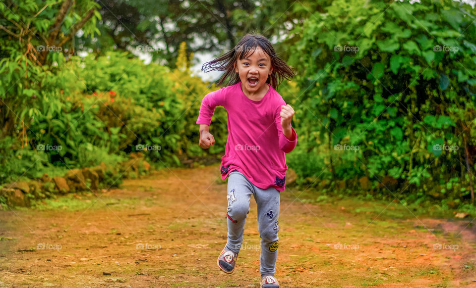 Sudden light rain adding to the excitement of the little girl in pink