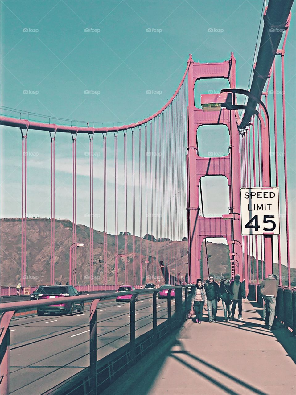 Tourists cross the famous Golden Gate Bridge despite the treacherous wind blowing them back.
