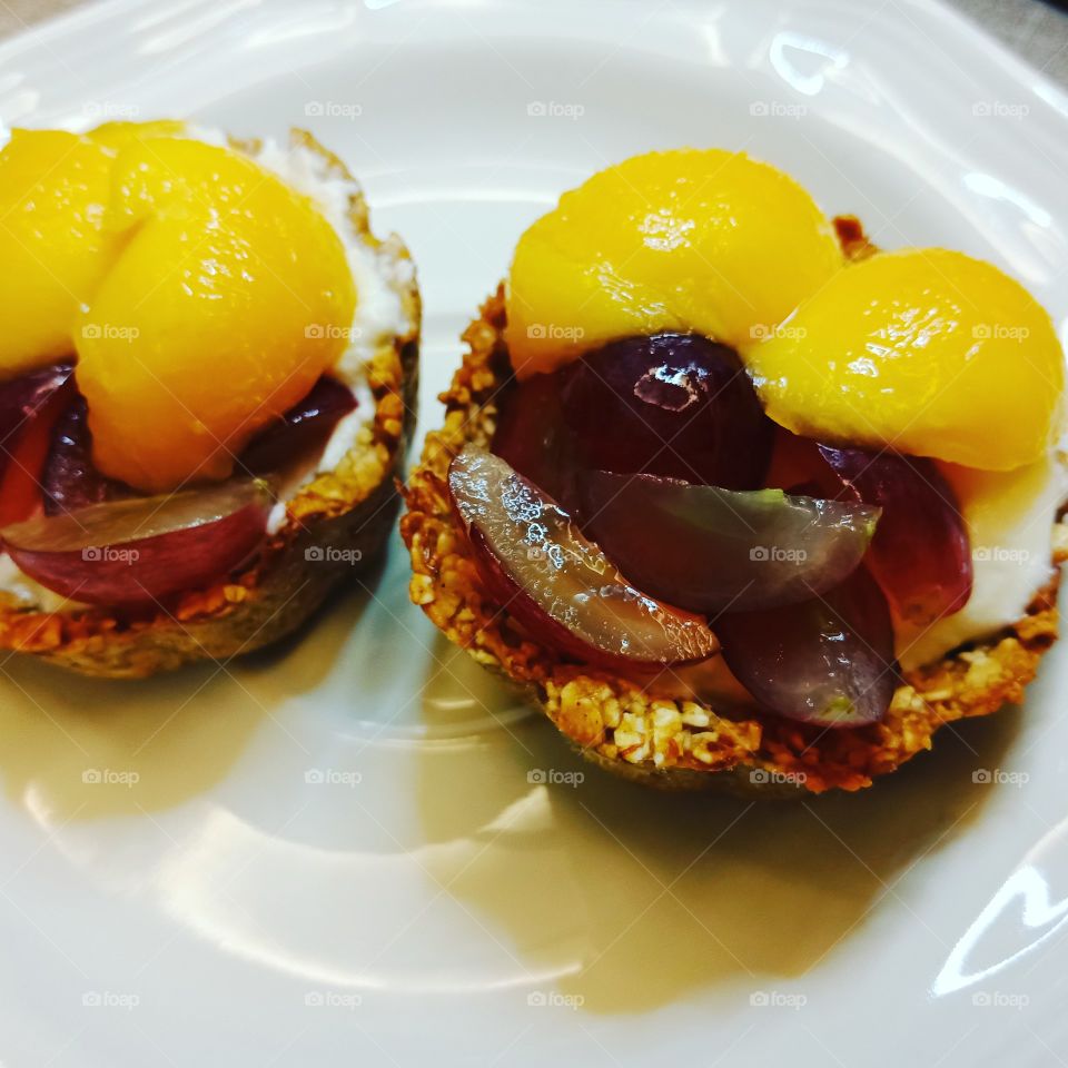 helthy breakfast I made from Pinterest.  The cups are made of rolled-oats,mashed banana,  honey and almond oil.  filling with cream cheese,  top with slices of mango and grapes.  😋 yummy