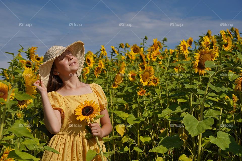 Girl in yellow dress with sunflower