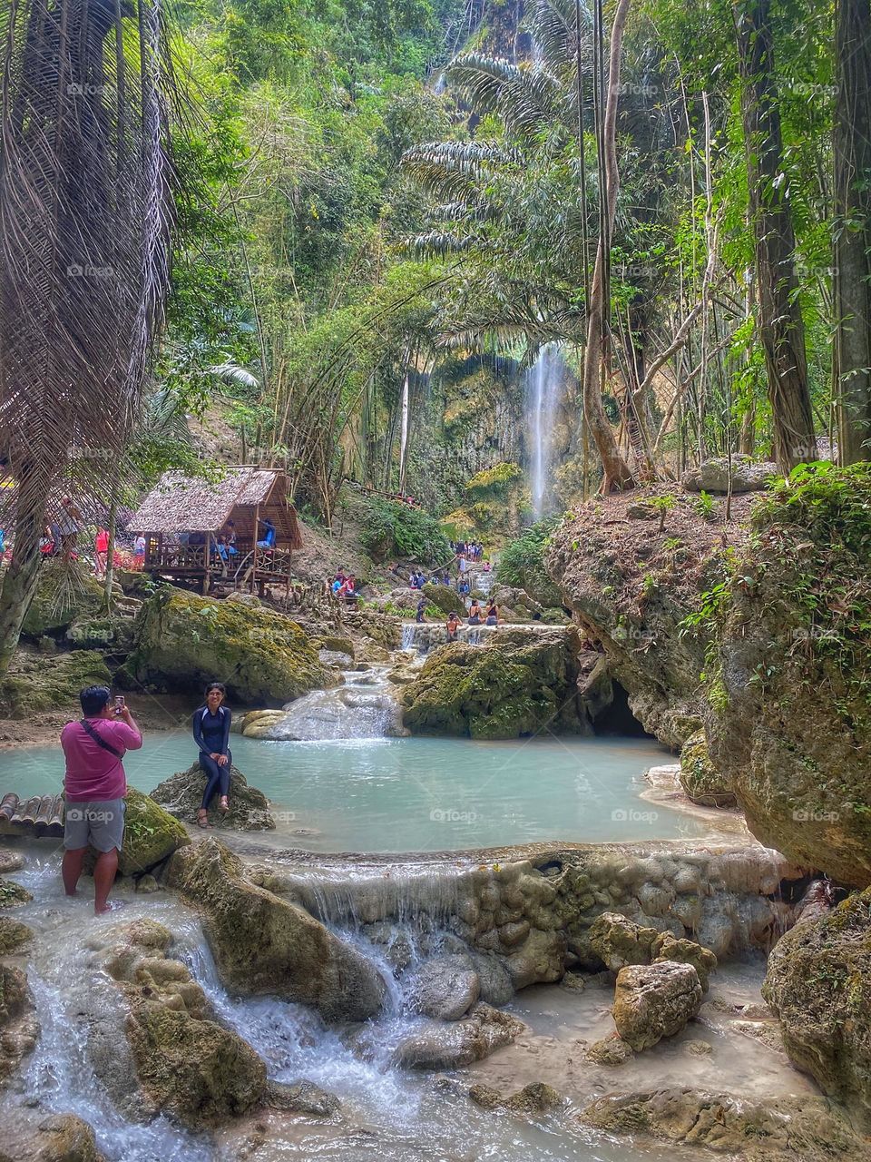Tourist enjoying the beautiful scenery of Tumalog Waterfall and trees, Oslob Cebu Philippines. 