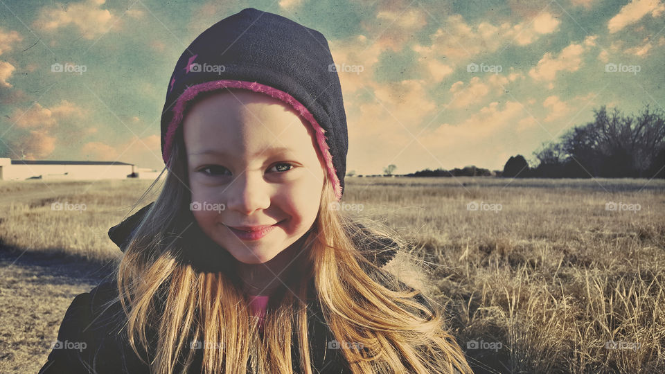 Close-up of small cute girl in field