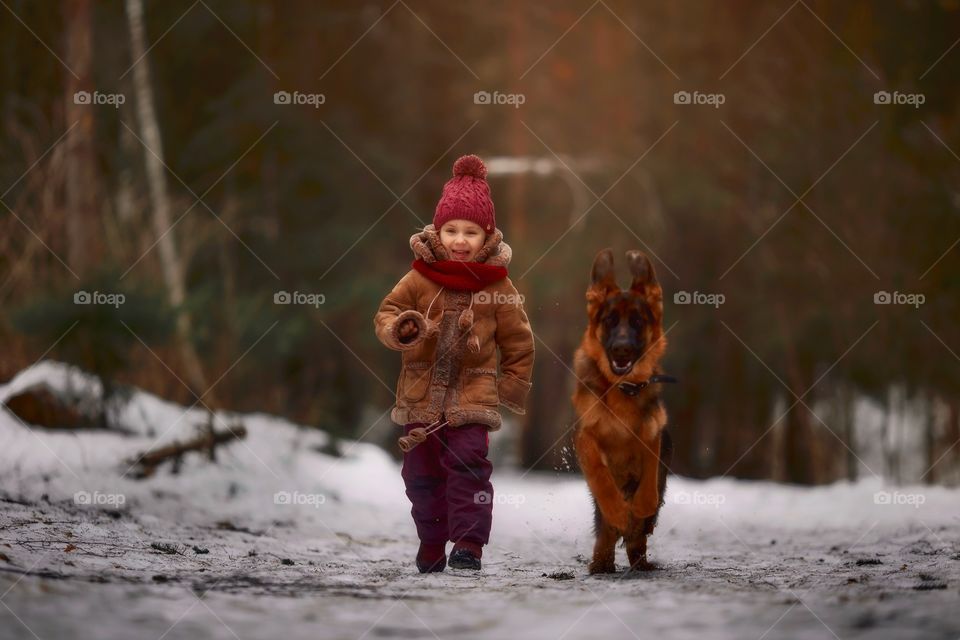 Little girl with German shepherd dog in a spring park 