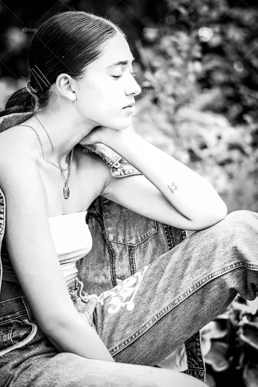 Young woman dressed in denim relaxing outdoors