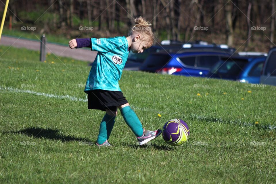 My four-year-old daughter dribbling a soccer ball during practice. 