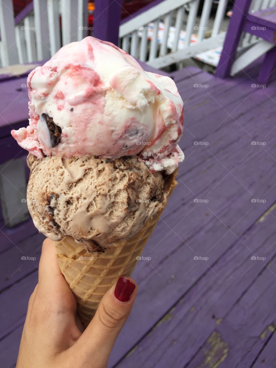 Person's hand holding ice cream cone