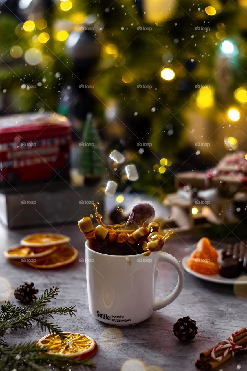 New Year's food still life white mug with coffee and flying sweets on the background of the Christmas tree