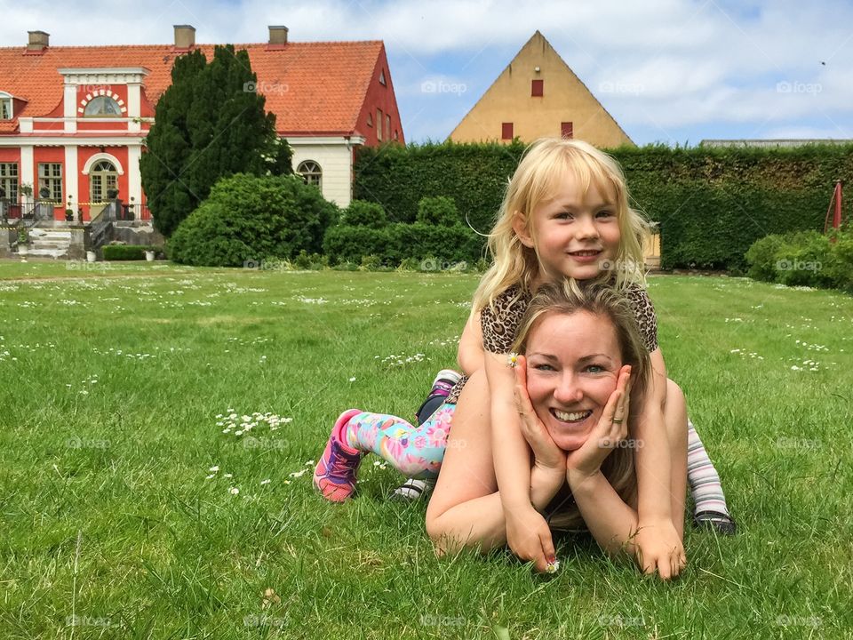 Mother with her daughter lying on grass