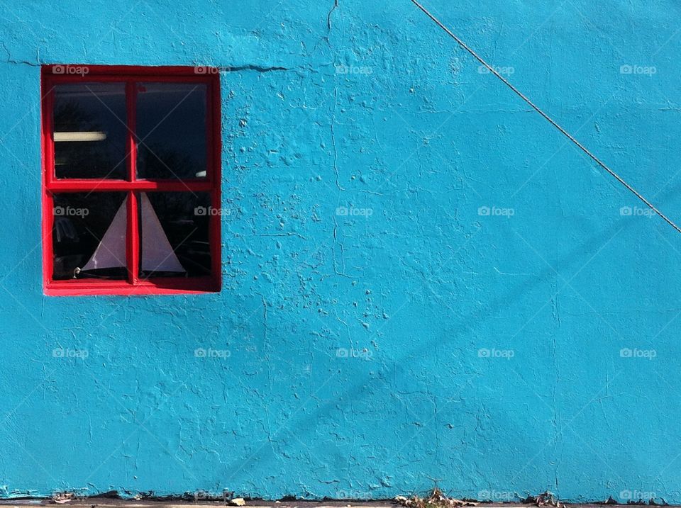 Blue Wall Red Window. A blue wall with a red window.