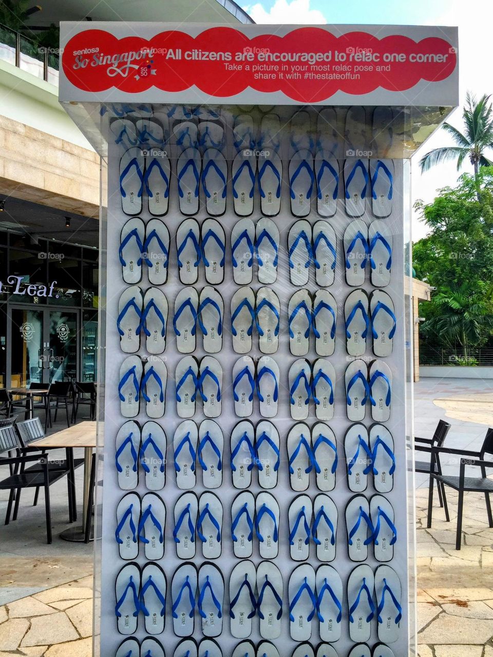 A bunch of the same blue and white slippers hanging behind the glass in the narrow showcase