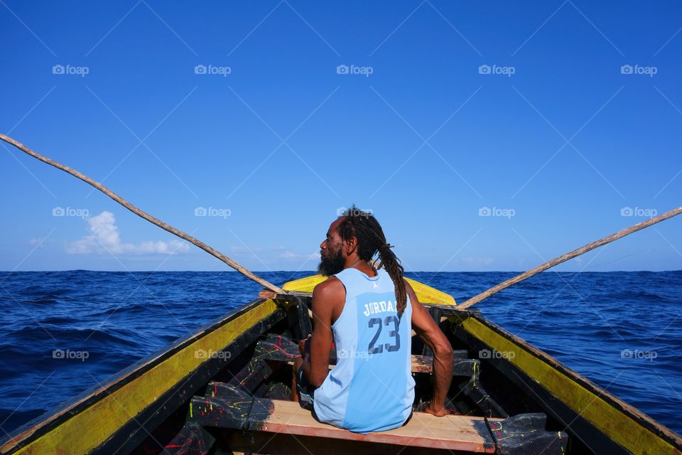Rasta fisherman in a boat. Rasta fisherman in a traditional wooden fishing boat in Port Antonio, Jamaica on New Year’s Eve 2013.