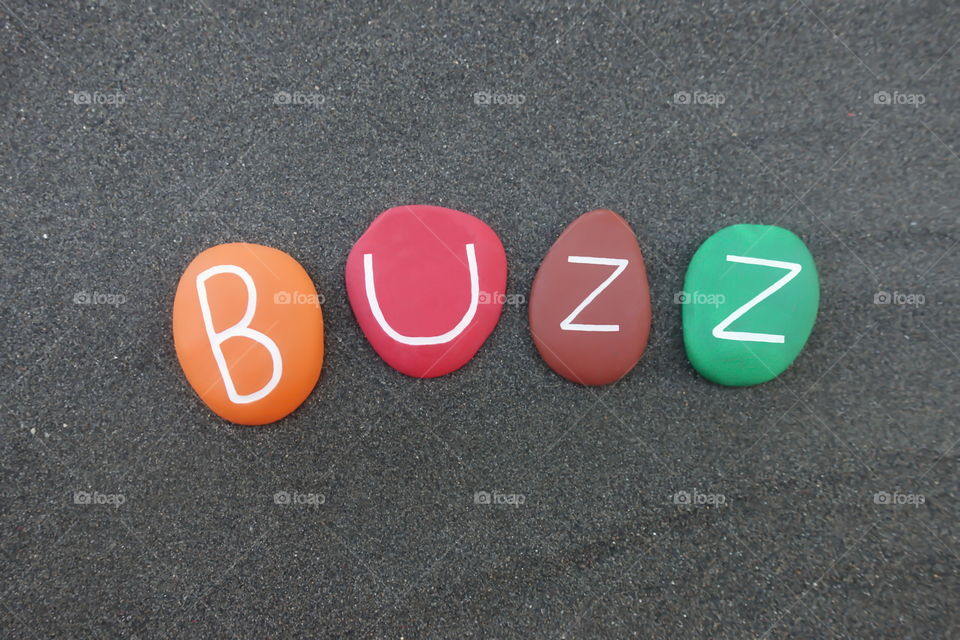 Buzz, masculine given name composed with colored stones over black volcanic sand