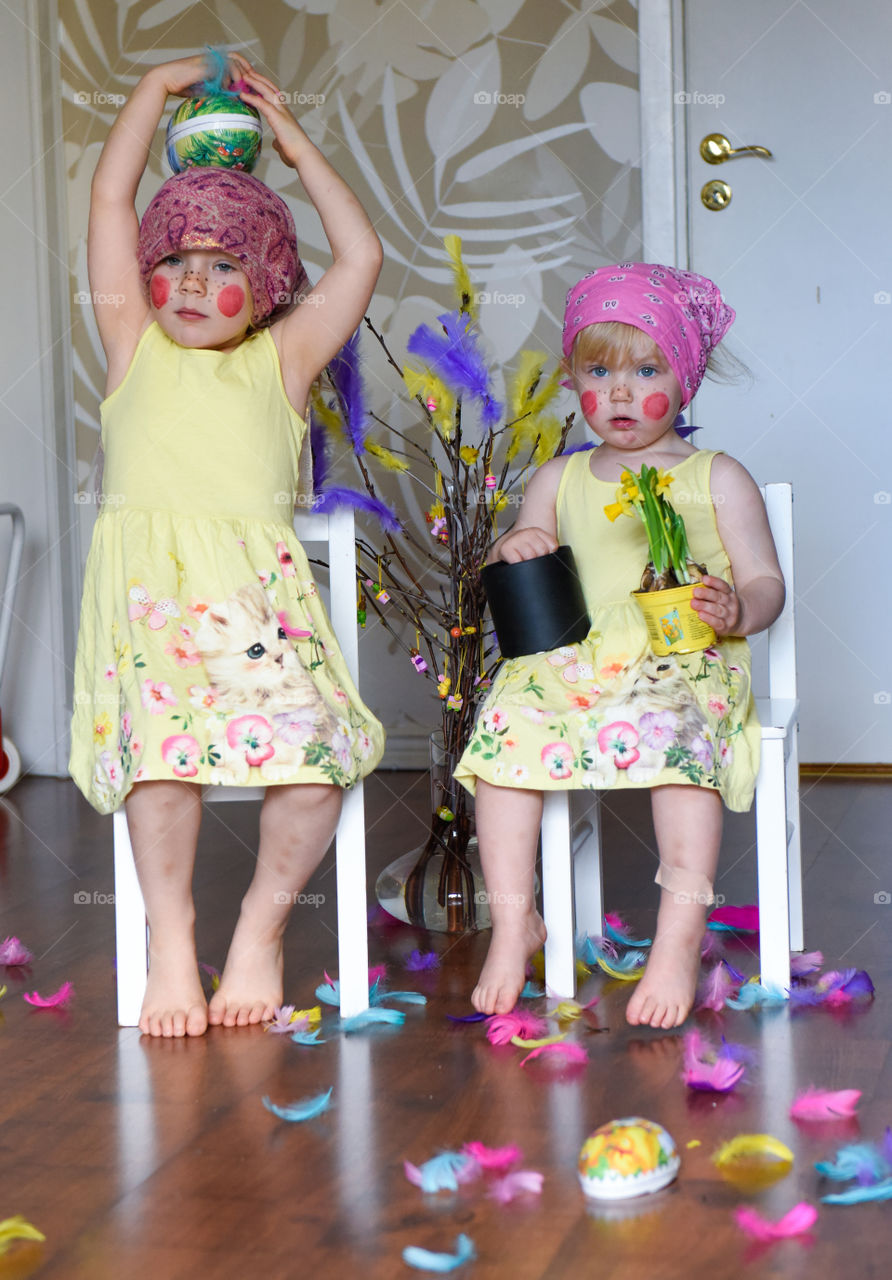 Two young sisters having fun infront of the camera with easter theme.